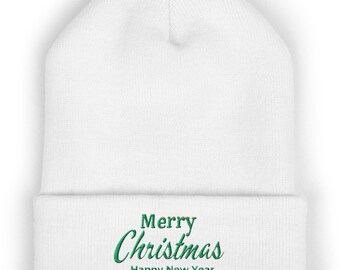 May include: A white knit beanie with a folded cuff featuring the embroidered green text Merry Christmas Happy New Year centered on the front. The hat is constructed from a soft fabric with a visible ribbed texture throughout the design.