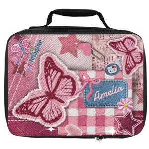 Op de afbeelding: Een rechthoekige lunchtas met een zwart handvat en rits, voorzien van een roze collageontwerp met spijkerstoftexturen, vlinders, sterren en een blauwe patch met de naam Amelia in het wit, naast een klein Hello Kitty-karaktericoontje.