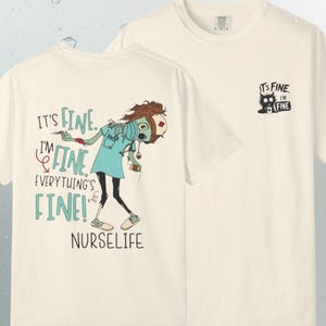 Peut inclure: Un t-shirt blanc cass&eacute; avec un motif au dos repr&eacute;sentant une infirmi&egrave;re zombie aux cheveux &eacute;bouriff&eacute;s, portant un masque et un st&eacute;thoscope, tenant une seringue. Le texte indique : It's fine. I'm fine. Everything's fine! NURSELIFE. Le devant pr&eacute;sente un petit chat noir.