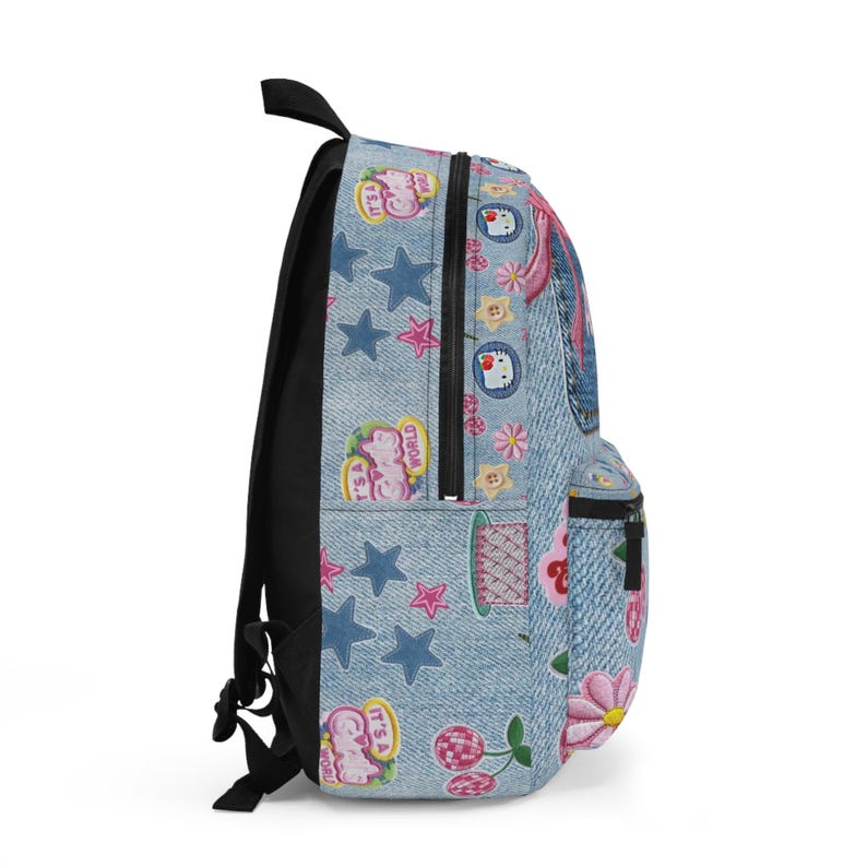 May include: A light blue denim-textured backpack featuring a variety of embroidered patches including pink flowers, red cherries, blue stars, and Hello Kitty icons. The bag has black zippers, black side panels, and black adjustable shoulder straps.