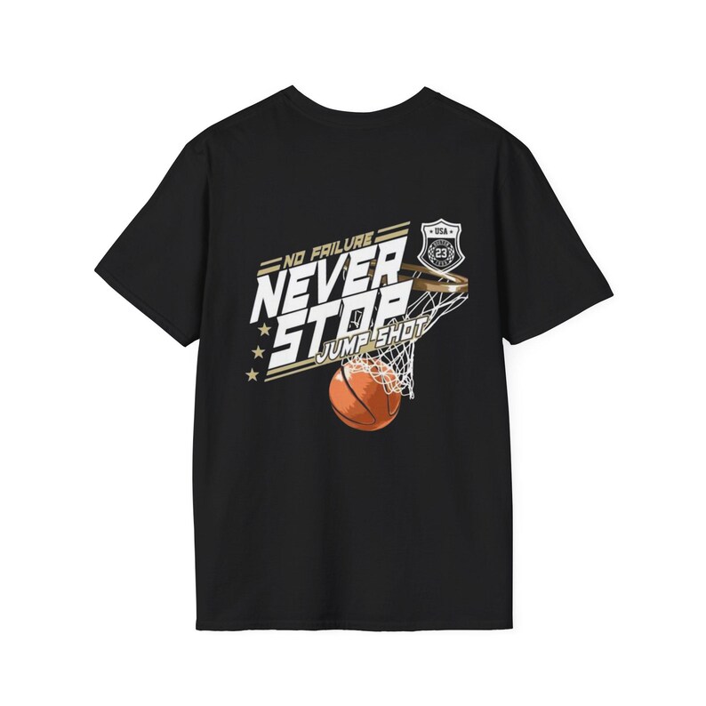 May include: A black short-sleeve t-shirt featuring a graphic of a basketball going through a hoop. The text reads NO FAILURE NEVER STOP JUMP SHOT with a small shield emblem containing the number 23 and the letters USA above the hoop.
