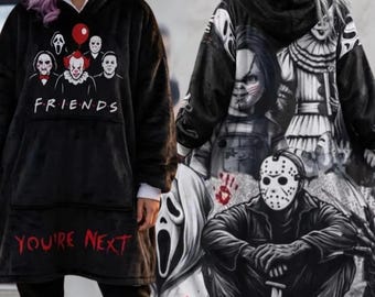Peut inclure: Un sweat à capuche noir oversize avec un graphisme frontal de personnages de films d'horreur, le texte FRIENDS et YOU'RE NEXT en rouge. Le dos présente un grand collage détaillé en noir et blanc de méchants de films d'horreur emblématiques.