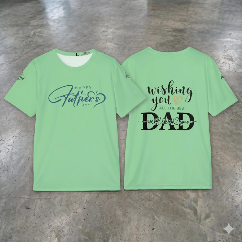 May include: Two light green t-shirts. The front of the first shirt has the text "Happy Father's Day" in blue script. The back of the second shirt says "Wishing You All The Best Dad We Love You" in black script with a heart.