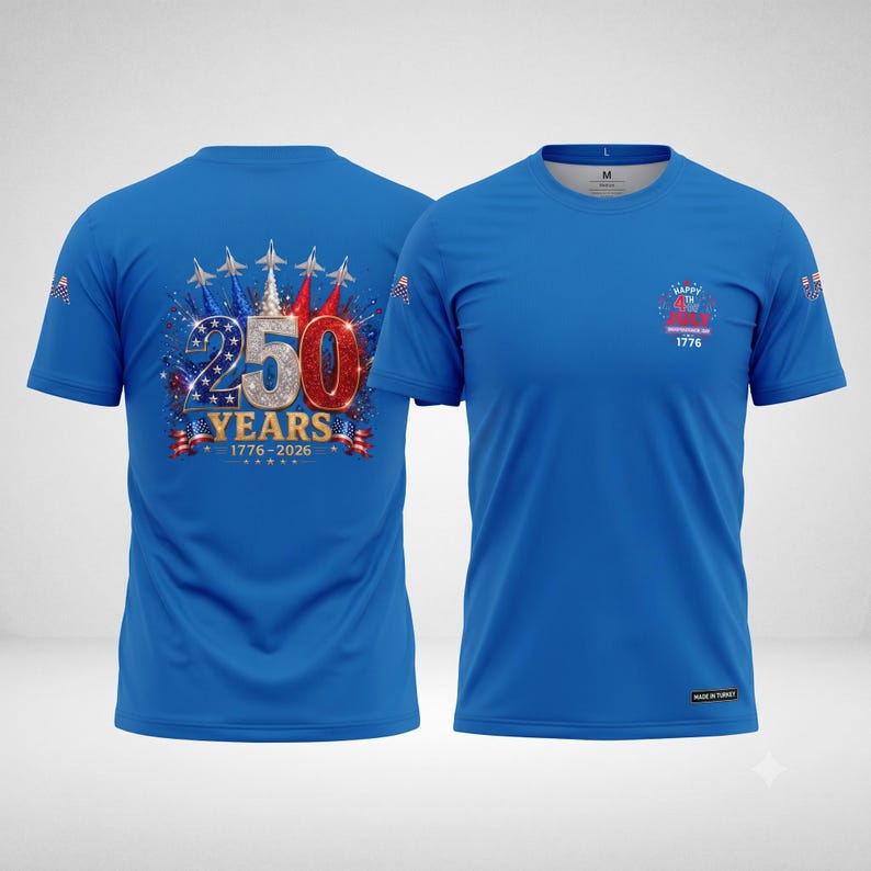 Puede incluir: Una camiseta azul de manga corta con un gr&aacute;fico en la espalda con el texto 250 YEARS 1776-2026, aviones de combate y fuegos artificiales. El frente muestra un peque&ntilde;o logo con el texto HAPPY 4TH OF JULY INDEPENDENCE DAY 1776. Iconos de banderas en las mangas.