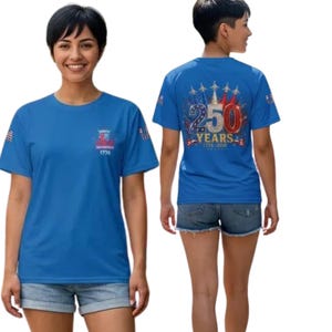 Puede incluir: Una camiseta azul brillante de manga corta con un peque&ntilde;o gr&aacute;fico en el pecho con el texto 1776. La parte posterior muestra un gr&aacute;fico grande con el n&uacute;mero 250, el texto YEARS, 1776-2026 y una ilustraci&oacute;n de cinco aviones de combate.