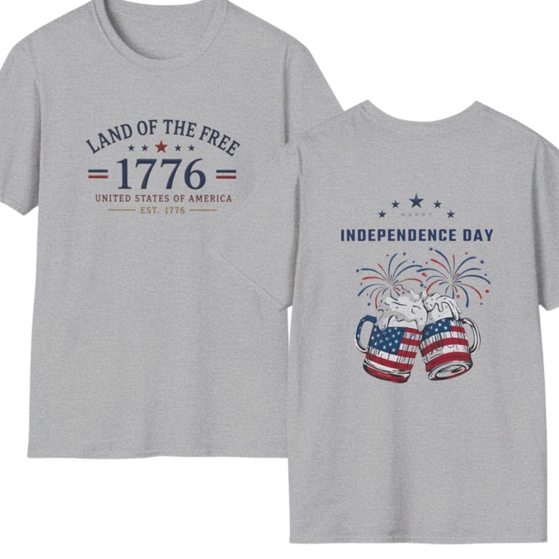 Pu&ograve; includere: Una t-shirt grigio melange con una grafica frontale con il testo LAND OF THE FREE 1776 UNITED STATES OF AMERICA EST. 1776 e una grafica sul retro che mostra due boccali di birra con motivi della bandiera americana, fuochi d'artificio e il testo HAPPY INDEPENDENCE DAY.