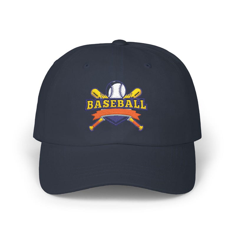 May include: A navy blue baseball cap featuring an embroidered logo on the front. The design includes two crossed yellow baseball bats behind a white baseball, a purple shield, an orange ribbon banner, and the word BASEBALL in yellow text.