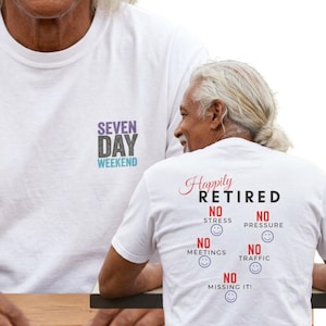 May include: A white t-shirt featuring a front chest graphic that reads SEVEN DAY WEEKEND in purple, gray, and teal. The back of the shirt displays the text Happily RETIRED with the phrases NO STRESS, NO PRESSURE, NO MEETINGS, NO TRAFFIC, and NO MISSING IT!