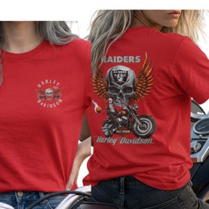 K&ouml;nnte beinhalten: Ein rotes T-Shirt mit einem kleinen Harley-Davidson-Logo auf der Brust. Die R&uuml;ckseite zeigt eine gro&szlig;e Grafik eines gefl&uuml;gelten Sch&auml;dels, eines Motorrads sowie den Schriftzug Raiders und Harley-Davidson mit einem Raiders-Logo.