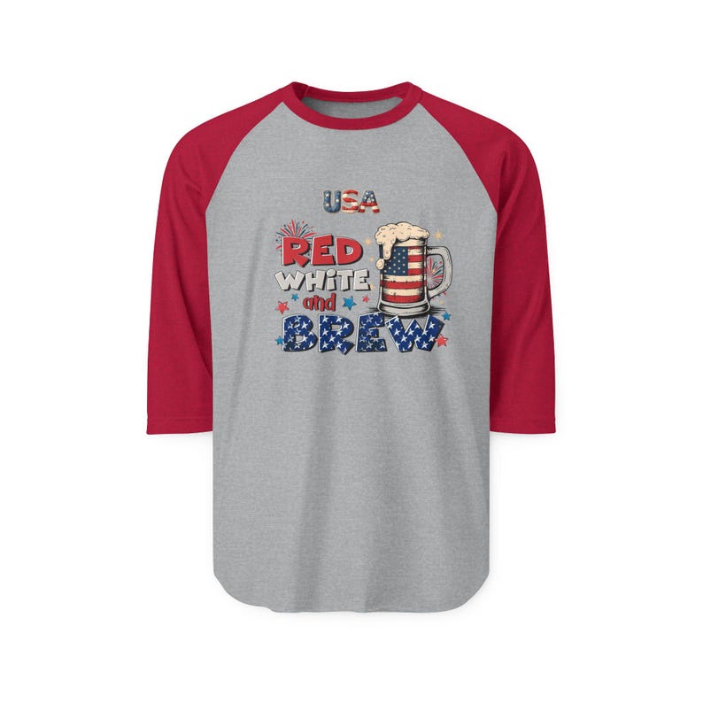Peut inclure: Un t-shirt de baseball gris avec des manches trois-quarts rouges pr&eacute;sentant un graphique d'une chope de bi&egrave;re avec un motif de drapeau am&eacute;ricain, de la mousse et le texte USA RED WHITE and BREW avec des petites &eacute;toiles rouges et bleues.