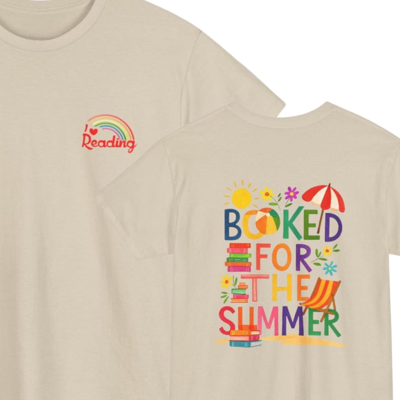 May include: A beige t-shirt featuring a small rainbow graphic with the text I heart Reading on the front left chest. The back displays a colorful graphic with the text BOOKED FOR THE SUMMER, surrounded by illustrations of books, a sun, and a beach chair.