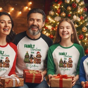 Op de afbeelding: Een set van vier raglan-shirts met witte body's en gekleurde mouwen in rood, zwart, groen en blauw. Elk shirt heeft een afbeelding van vier honden in kerstkleding, de tekst "FAMILY Christmas 2026" en de naam "The Williams" op de voorzijde.