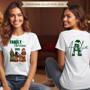 Puede incluir: Una camiseta blanca de manga corta con un gr&aacute;fico de cuatro perros salchicha con ropa festiva y el texto "FAMILY CHRISTMAS 2026 together" en el frente, y una letra "A" grande con patr&oacute;n de copos de nieve verdes y un gorro de Pap&aacute; Noel detr&aacute;s.