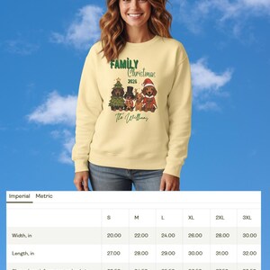 K&ouml;nnte beinhalten: Ein blassgelbes Sweatshirt mit Rundhalsausschnitt und einer Grafik von vier Dackeln in festlicher Kleidung sowie dem Text Family Christmas 2026 The Williams. Unter dem Sweatshirt befindet sich eine Gr&ouml;&szlig;entabelle mit Ma&szlig;en in Zoll f&uuml;r S bis 3XL.