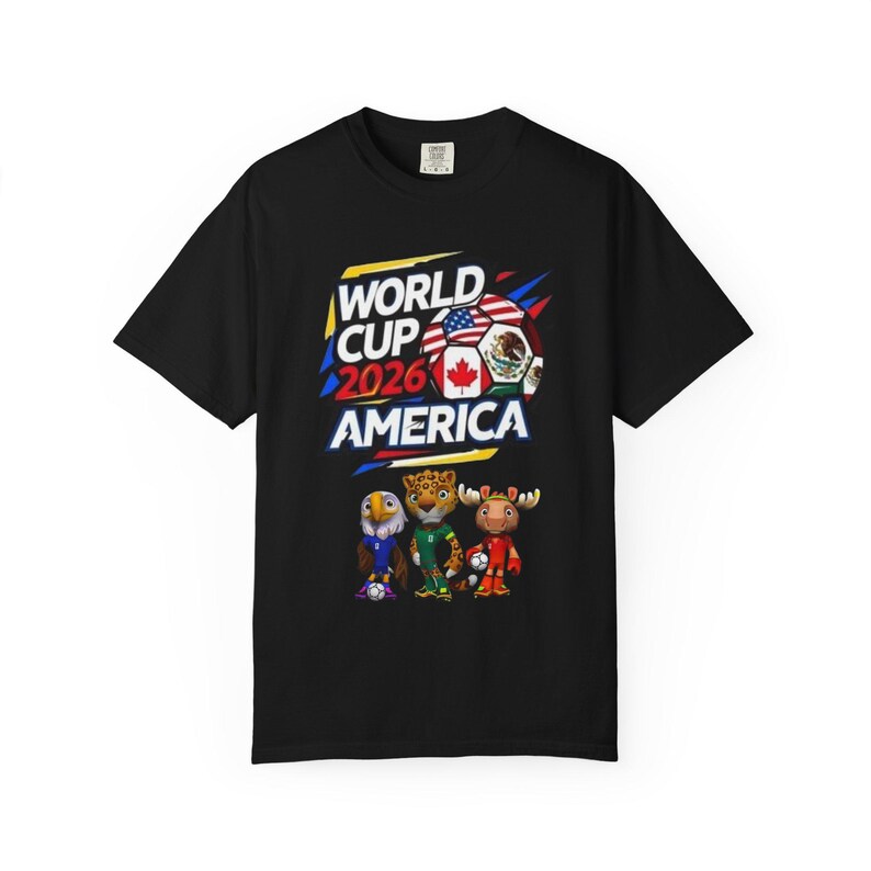 May include: Black t-shirt featuring the text "WORLD CUP 2026 AMERICA" with the flags of the United States, Canada, and Mexico. The shirt also displays cartoon mascots of an eagle, jaguar, and moose, each holding a soccer ball.