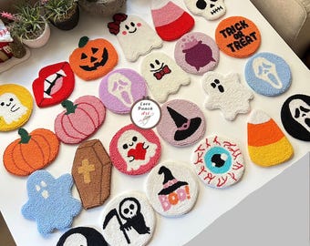 May include: A selection of handmade Halloween coasters featuring various designs such as pumpkins, ghosts, and skulls. The coasters are circular and crafted from a textured yarn in a range of colours, ideal for seasonal home decor. Each coaster is approximately 10 cm in diameter.