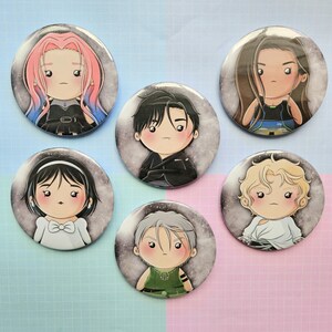 Op de afbeelding: Zes ronde buttons met cartoonillustraties van personages met verschillende kapsels en outfits. De personages hebben grote ogen en blozen. De buttons hebben een grijs-witte achtergrond met een sterrenhemel-effect.
