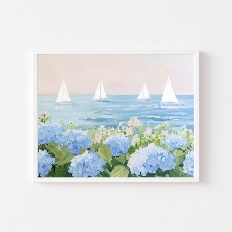 Pu&ograve; includere: Dipinto incorniciato raffigurante una scena costiera con barche a vela sull'acqua e ortensie blu in primo piano. Il cielo &egrave; rosa tenue e l'acqua azzurra. Le barche a vela hanno vele bianche.