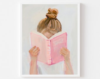 Puede incluir: Una impresión artística enmarcada de una persona leyendo un libro rosa. La cara de la persona está oculta por el libro, solo se ven las manos y el moño. La obra de arte está pintada en suaves tonos rosas, blancos y marrones.