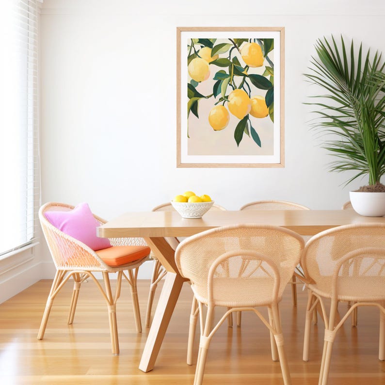 May include: A framed art print featuring a watercolor painting of lemons on a branch. The artwork is displayed above a wooden dining table with woven chairs. A bowl of lemons sits on the table, and a potted plant is in the background.