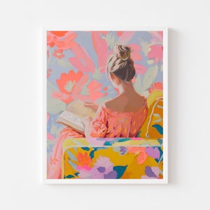May include: A woman in a pink dress sits in a yellow armchair with floral upholstery. She is reading a book and has her back to the viewer. The background is a wall with a floral pattern in shades of pink and blue.