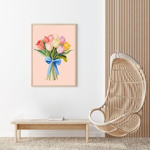 Pode incluir: Uma pintura digital de um buqu&ecirc; de tulipas rosa, amarelas e laranja amarradas com uma fita azul sobre um fundo rosa claro.