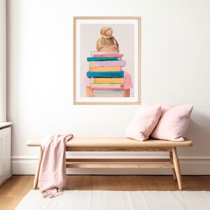 Może przedstawiać: Ilustracja w ramie przedstawiająca osobę z rozczochranym kokiem, stojącą przed stosami kolorowych książek, kt&oacute;re zasłaniają jej twarz.