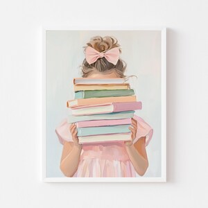 May include: A framed print of a young person holding a stack of colorful books. The person is wearing a pink dress and has a pink bow in their hair. The books are in pastel colors.
