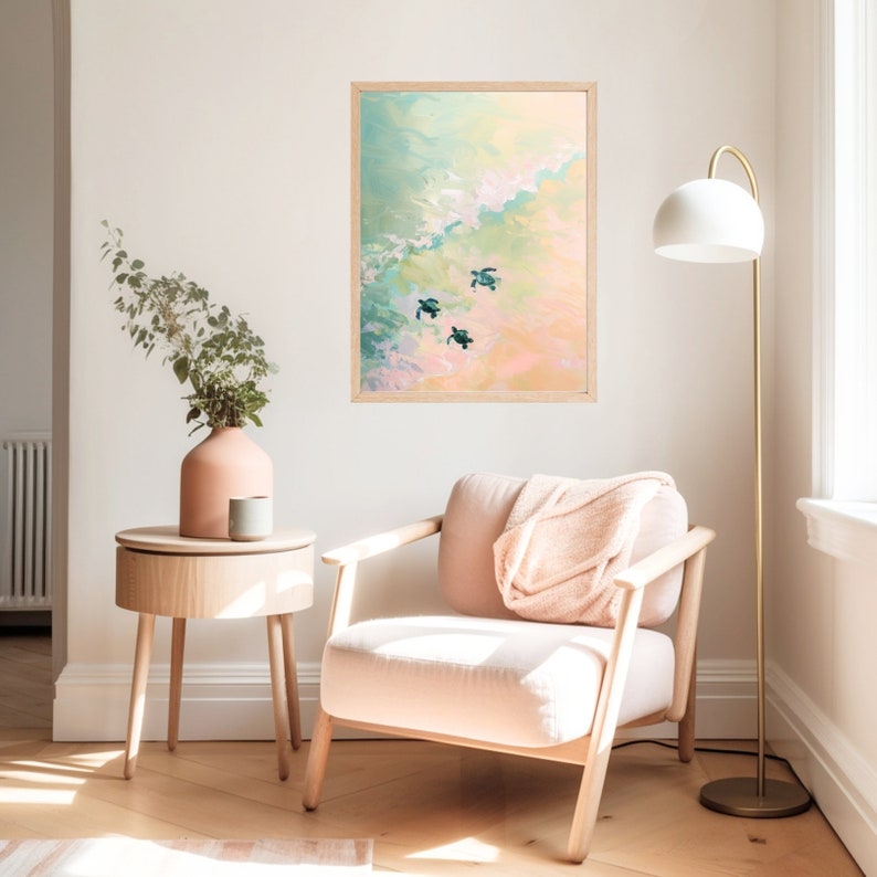 Puede incluir: Una pintura enmarcada de un paisaje mar&iacute;timo con tres tortugas marinas nadando en el agua. La pintura est&aacute; en tonos de azul, verde y rosa, y se encuentra en una pared blanca. Un sill&oacute;n rosa y una mesa auxiliar de madera est&aacute;n en primer plano.