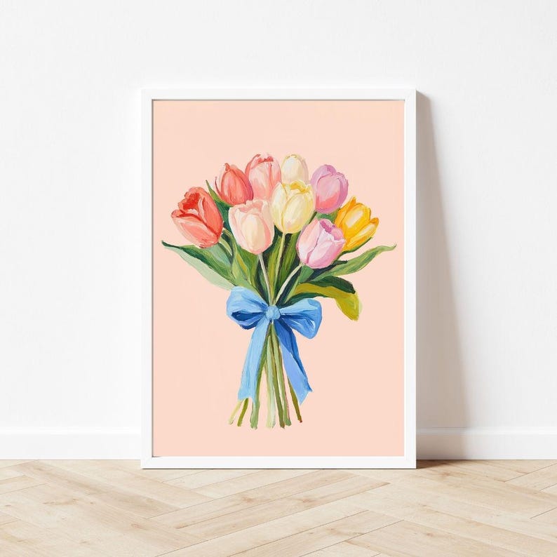 Pode incluir: Um buqu&ecirc; de tulipas coloridas amarradas com uma fita azul sobre um fundo rosa claro.