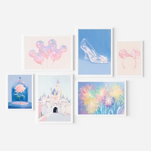 Op de afbeelding: Een galerijwandset van zes ingelijste prints met illustraties van roze Mickey-vormige ballonnen, een glazen muiltje op blauw, roze muisoren, een roos in een glazen stolp, een groot kasteel en kleurrijk vuurwerk tegen een blauwe achtergrond.