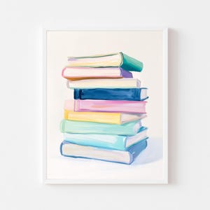 May include: A framed print featuring a stack of colorful books. The books are painted in shades of green, blue, pink, yellow, and purple. The artwork is set against a white background, creating a vibrant and eye-catching display.
