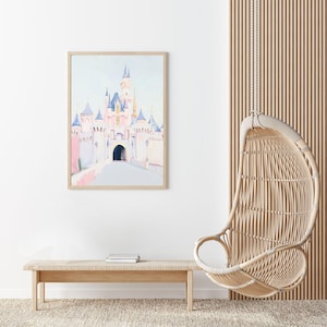 May include: A framed watercolor print of a fairytale castle in soft pink, blue, and white tones. The artwork is displayed above a light wood bench with books, next to a hanging wicker chair. The room has a neutral color palette.