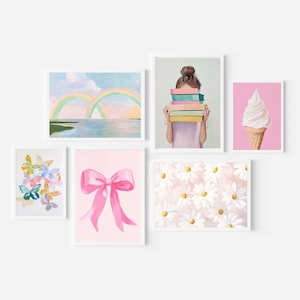 May include: A set of framed art prints. The collection includes a rainbow over water, a person holding books, a pink bow, a butterfly watercolor, a daisy pattern, and an ice cream cone. The art uses a pastel colour palette.