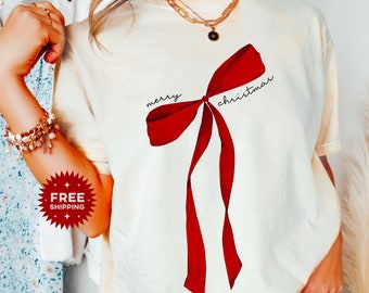 May include: A white t-shirt with a red bow and the text "merry christmas" printed on it.