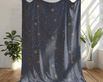 以下が含まれることがあります： 星、星座、太陽の光線を特徴とする金色の天体模様が施されたネイビーブルーの毛布。毛布は柔らかく、豪華な生地で作られており、どんな部屋にも幻想的な雰囲気を加えるのに最適です。