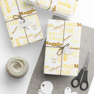 Puede incluir: Papel de regalo blanco con un patr&oacute;n repetido amarillo y marr&oacute;n del nombre "Maggie".