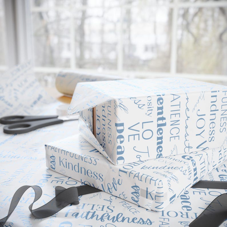 Puede incluir: Dos cajas de regalo blancas envueltas en papel blanco con texto azul. El texto incluye palabras como "amor", "alegr&iacute;a", "paz", "fe", "bondad" y "gentileza".