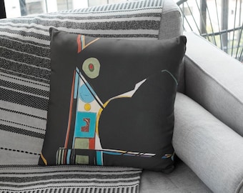 Puede incluir: Una manta de tiro a rayas blancas y negras con una almohada negra que presenta un diseño abstracto colorido. La almohada tiene un patrón geométrico con acentos rojos, amarillos, azules y verdes.