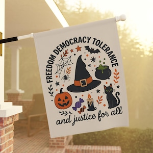 May include: A cream-colored garden flag featuring a black witch hat, a jack-o'-lantern, a black cat, a cauldron, and candy. The text reads FREEDOM DEMOCRACY TOLERANCE and and justice for all in black lettering, surrounded by spiderwebs and stars.