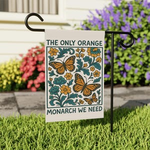 Subtle anti Trump flag reading The Only Orange Monarch We Need with bright orange butterflies and flowers, a funny political garden flag that adds activism and humor to your yard.