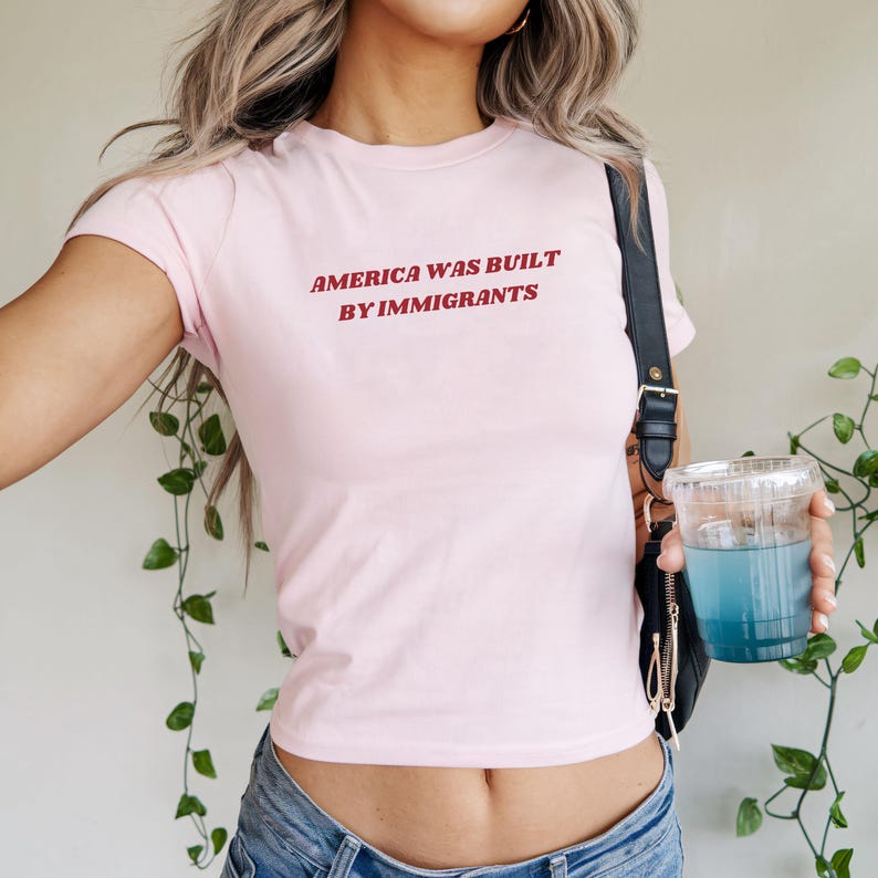 Y2k Baby Tee In Pink With Red Text "America Was Built By Immigrants. A Political Activist Tee And Pro Immigration Shirt For Women.