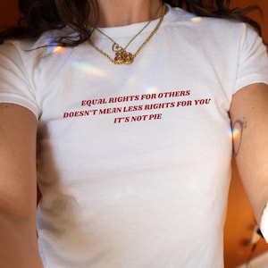 Puede incluir: Camiseta blanca con el texto "Equal rights for others doesn't mean less rights for you. It's not pie." impreso en rojo.