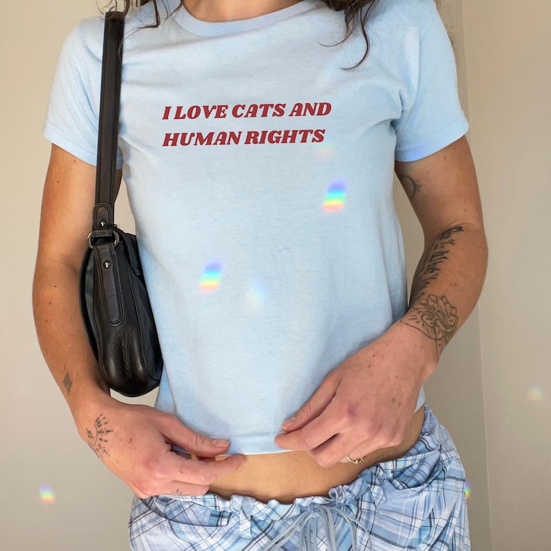 Light blue baby tee with feminism quote 'I Love Cats and Human Rights.' Feminist Y2K baby tee for cat lovers and advocates of gender equality and social justice.
