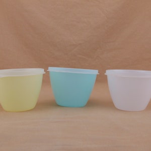 Peut inclure: Trois contenants en plastique avec couvercles. Les contenants sont jaunes, bleu clair et blancs.