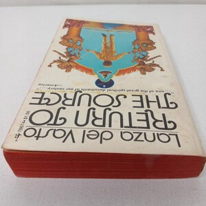 Puede incluir: Una portada de libro vintage con fondo blanco y texto rojo. El t&iacute;tulo es "Regreso a la Fuente" de Lanza del Vasto. El texto est&aacute; en negrita, fuente sin serif. La portada presenta una ilustraci&oacute;n colorida de una persona de pie boca abajo en una puerta.