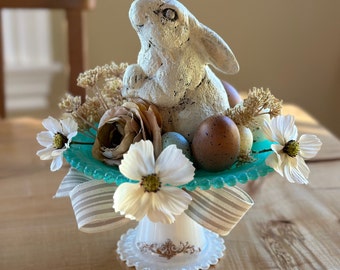 EGGSTRA simpatico coniglietto su un'alzatina dipinta, con fiori selvatici e uova maculate, fiocco in lino a righe. Pasqua/Primavera/Agriturismo/Cottage/Shab Chic
