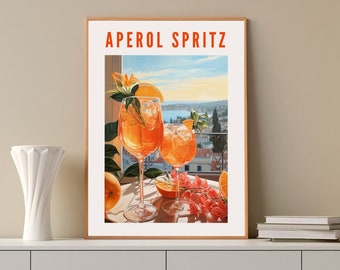 May include: A framed print with the text "APEROL SPRITZ" in orange letters. The print features a painting of two glasses of Aperol Spritz with orange slices and a sprig of rosemary, set against a backdrop of a scenic view of a city and a body of water.