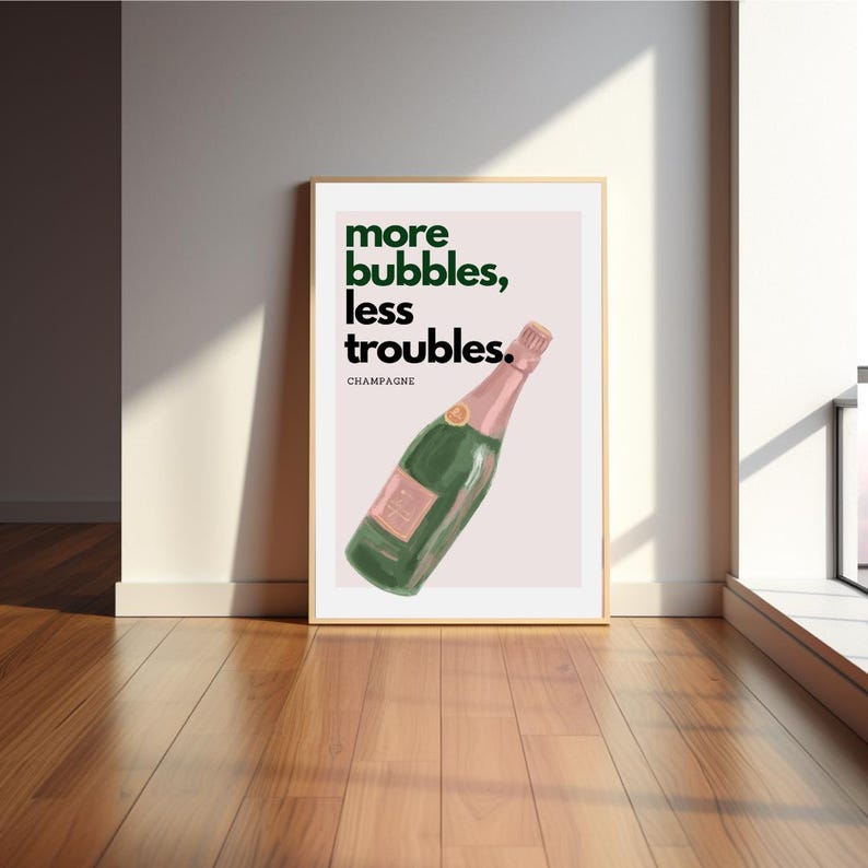 May include: A framed art print featuring a champagne bottle illustration. The bottle is green with a pink label and top. The print has the text "more bubbles, less troubles" in green, with "champagne" below.