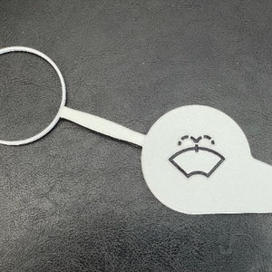 May include: White plastic car windshield washer fluid reservoir cap with a black icon of a windshield and water droplets.